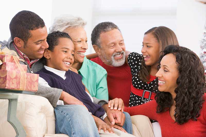 Multigenerational family gathered together in a living room.